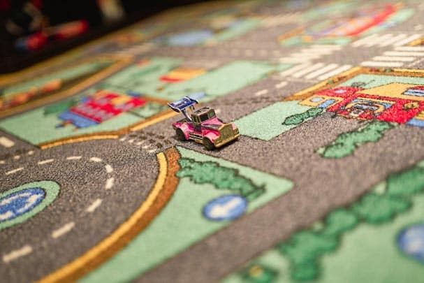 Nahaufnahme von Monopoly-Auto auf Spieleteppich mit Straßen