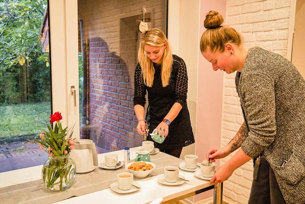 Zwei Frauen bereiten Kaffee und Kekse zu